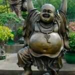 Happy overweight man with open belly fat dancing statue.