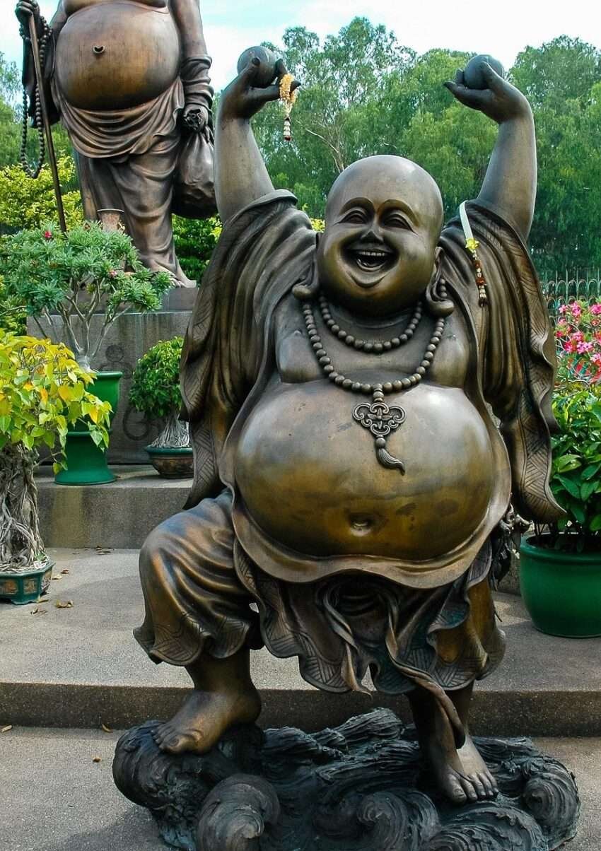 Happy overweight man with open belly fat dancing statue.